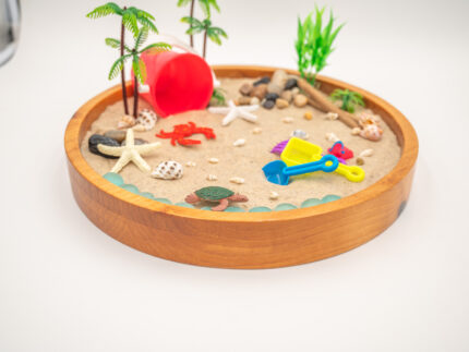 Beach Sensory Bin with Sand featuring real shells, sea creatures, palm trees, scoops, sifters, rocks, and red bucket for ocean sensory play