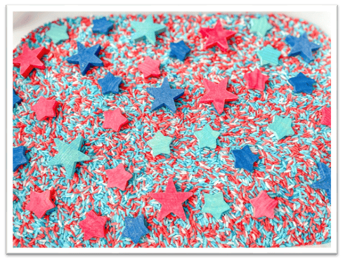 A colorful sprinkles and stars on a white tray