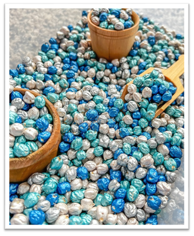 A group of small bowls and wooden spoons with blue and silver chickpeas