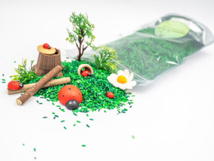 Ladybug Budget Bag with green grass rice wooden ladybugs logs and garden accessories