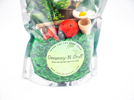 Ladybug Budget Bag with green grass rice wooden ladybugs logs and garden accessories