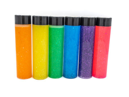 Six glitter calming bottles in pink, orange, yellow, green, blue, and purple with sparkly glitter