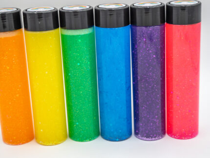 Six glitter calming bottles in pink, orange, yellow, green, blue, and purple with sparkly glitter
