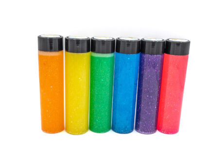 Six glitter calming bottles in pink, orange, yellow, green, blue, and purple with sparkly glitter