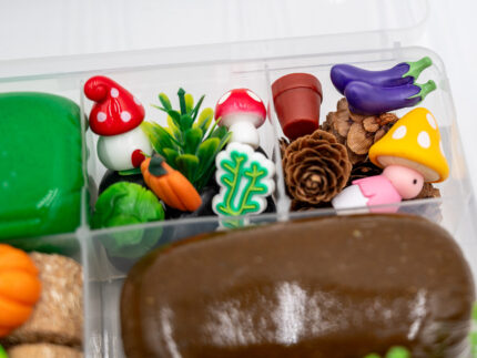 Deluxe Gardening Play-Doh Kit with colorful dough and miniature vegetables, flowers, plants, garden accessories, basket, and nature-themed pieces