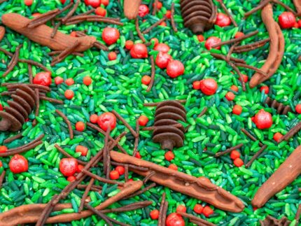 Holly Woods Sensory Filler with green rice, red berry-inspired accents, and brown woodland pieces for Christmas sensory play