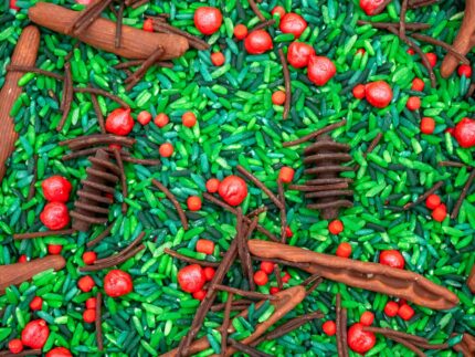 Holly Woods Sensory Filler with green rice, red berry-inspired accents, and brown woodland pieces for Christmas sensory play
