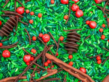 Holly Woods Sensory Filler with green rice, red berry-inspired accents, and brown woodland pieces for Christmas sensory play