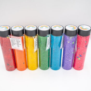 I Spy Bottles filled with rainbow colored rice and hidden items, with laminated word lists and picture cards