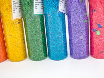 I Spy Bottles filled with rainbow colored rice and hidden items, with laminated word lists and picture cards
