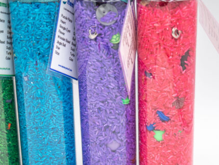 I Spy Bottles filled with rainbow colored rice and hidden items, with laminated word lists and picture cards