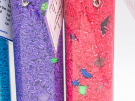 I Spy Bottles filled with rainbow colored rice and hidden items, with laminated word lists and picture cards