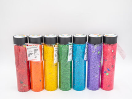 I Spy Bottles filled with rainbow colored rice and hidden items, with laminated word lists and picture cards