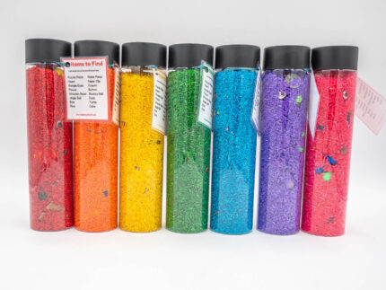 I Spy Bottles filled with rainbow colored rice and hidden items, with laminated word lists and picture cards