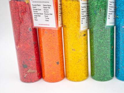 I Spy Bottles filled with rainbow colored rice and hidden items, with laminated word lists and picture cards