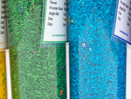 I Spy Bottles filled with rainbow colored rice and hidden items, with laminated word lists and picture cards