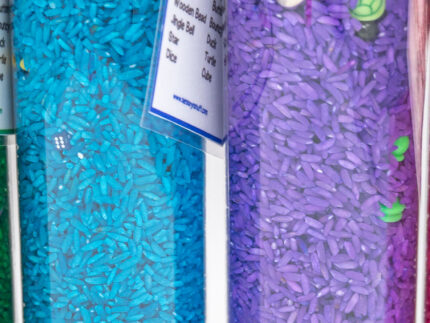 I Spy Bottles filled with rainbow colored rice and hidden items, with laminated word lists and picture cards
