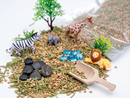 Safari Budget Bag with split peas, dyed pasta, lion, giraffe, elephant, zebra, tree, bushes, rocks, blue flat-back marbles, and wooden scoop