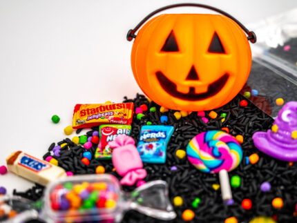 Trick-or-Treat Budget Bag with black rice, rainbow couscous, jack-o'-lantern container, pretend candy, Halloween charms, and ghost eraser